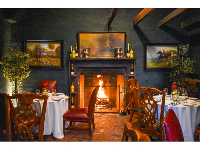 Dining room image with fireplace background and tables with white tablecloths