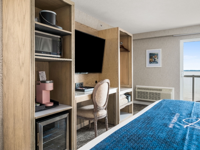 Lakeview balcony king room with mini refrigerator, microwave, 55" TV, coffee machine, private desk, and wardrobe
