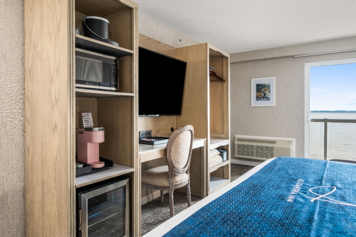 Lakeview balcony king room with mini refrigerator, microwave, 55" TV, coffee machine, private desk, and wardrobe