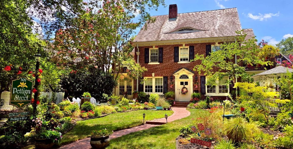 Red Brick historic two-story inn with blooming garden.