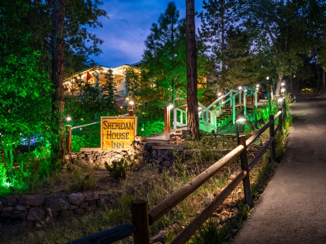 night view of a lighted building, Sheridan House Inn lighted sign and driveway leading to inn