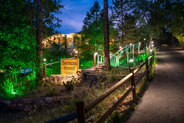 night view of a lighted building, Sheridan House Inn lighted sign and driveway leading to inn