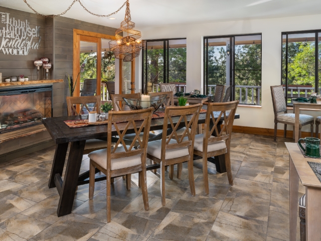 dining room with large table and chairs in front of fireplace with sliding glass door leading to a patio
