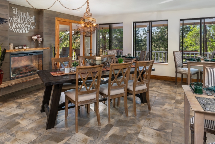 dining room with large table and chairs in front of fireplace with sliding glass door leading to a patio