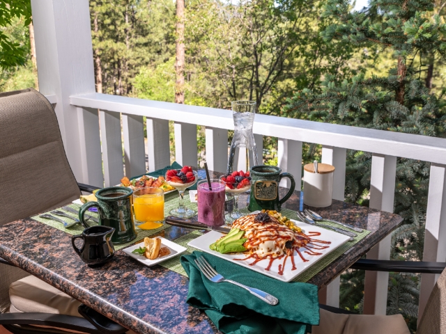Outdoor table for 2 set up for breakfast with coffee, juice and entrees