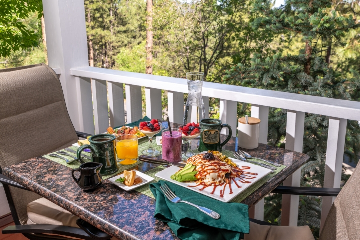 Outdoor table for 2 set up for breakfast with coffee, juice and entrees