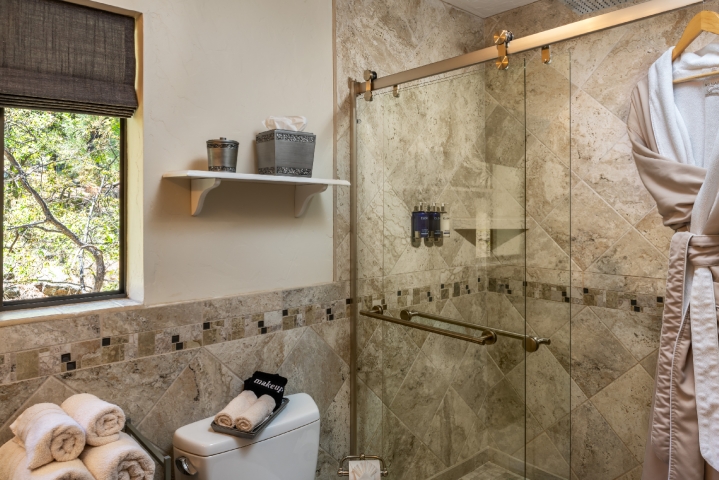 tiled shower with glass doors and rain shower