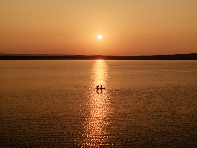 Family paddle boarding in East Grand Traverse Bay during stay at Alexandra Inn