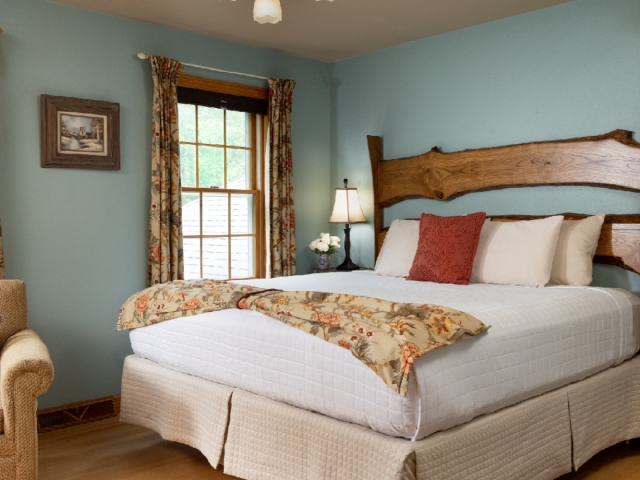 guestroom with blue walls and wood headboard