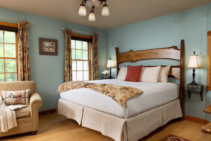 guestroom with blue walls and wood headboard
