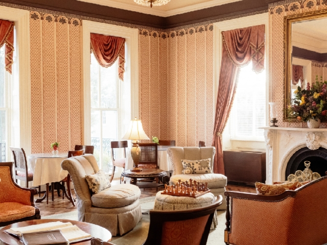 Elegant living room with large windows and seating area with couches and elegant chairs