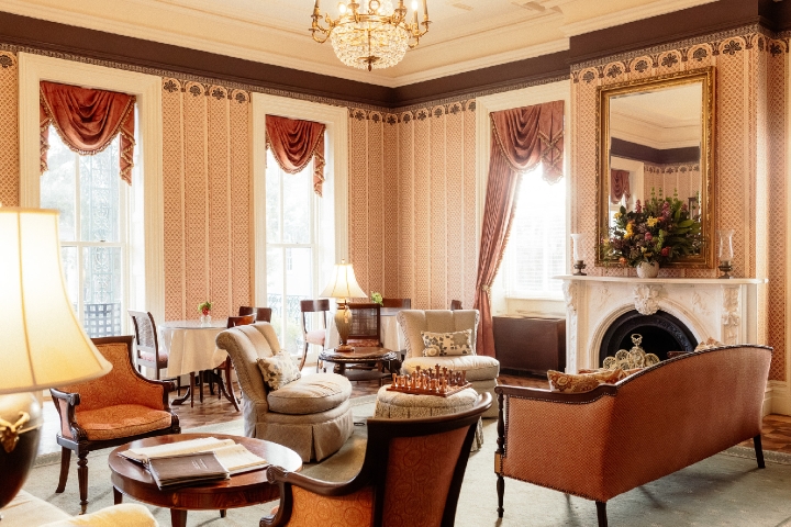 Elegant living room with large windows and seating area with couches and elegant chairs