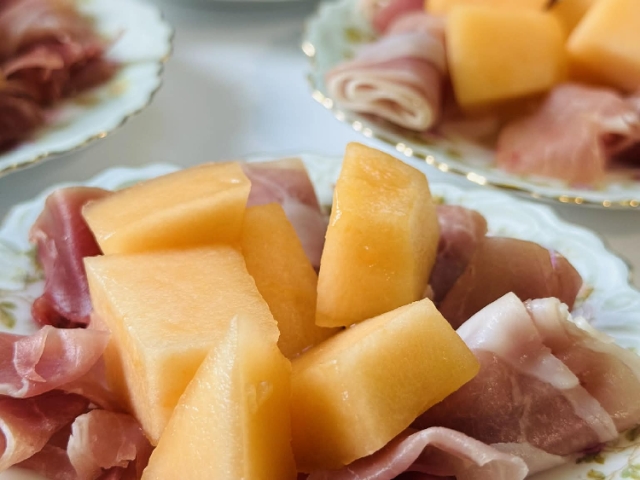 Prosciutto and melon, served on plates old enough to have outlived generations—some from the 1800s—because beauty tastes different when it’s carried on history.