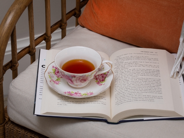 A cozy chair awaits at Prairie Guest House, inviting guests to relax with a steaming cup of tea and an open book.