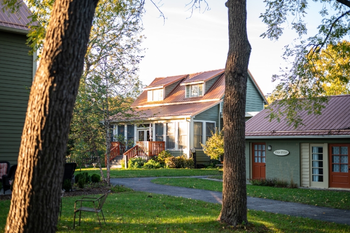 Sunlight bathes Prairie Guest House, nestled among beautifully manicured courtyard gardens and surrounded by towering native trees.