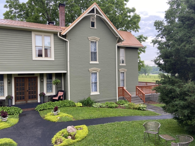 Inviting two-story guest house nestled among lush courtyard gardens and towering native trees, offering a peaceful retreat surrounded by nature.